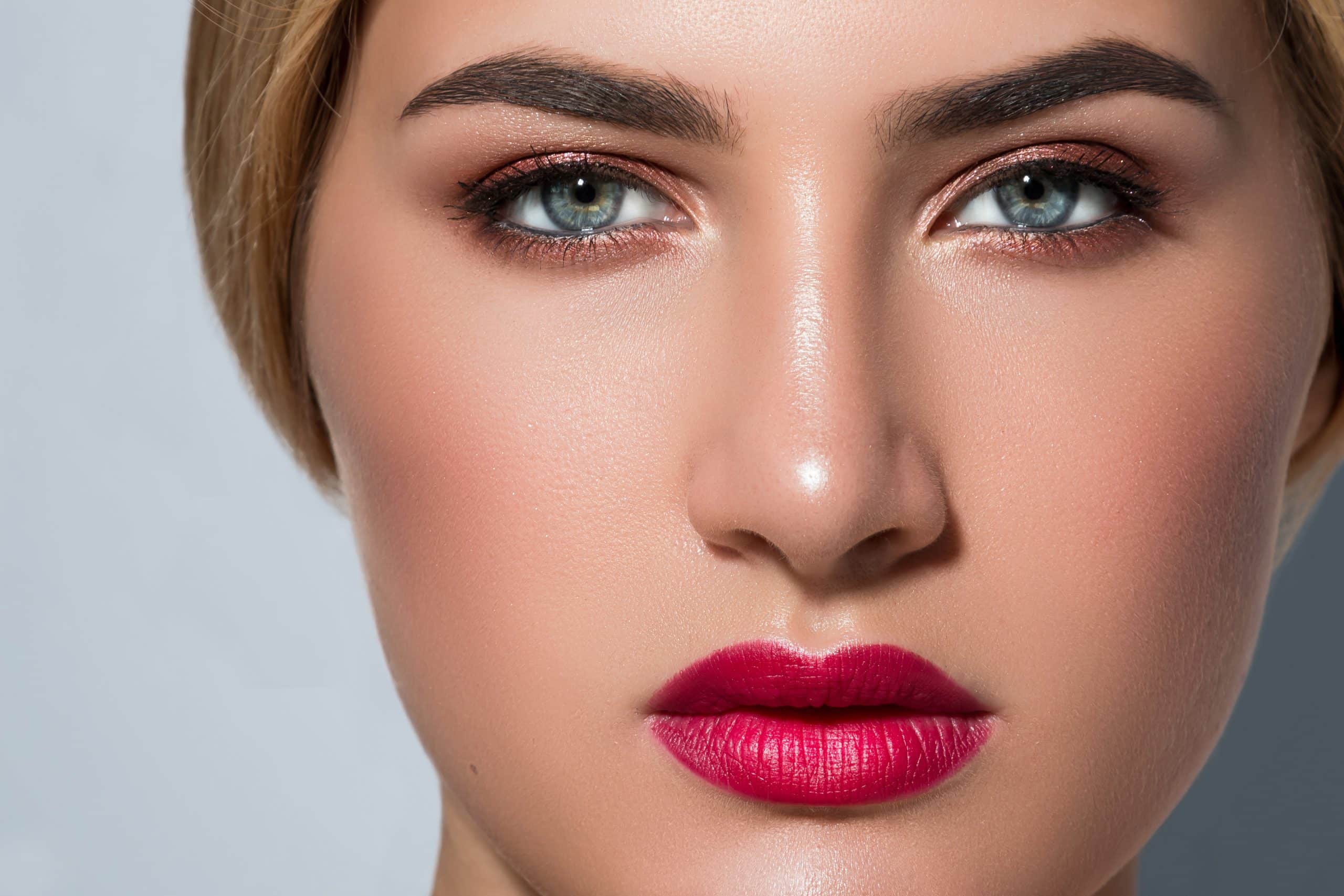 Schöne Frau mit Permanent Make-up und shcönen roten Lippen